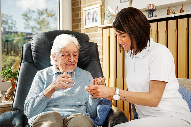 woman helping grandmother drinking medicine